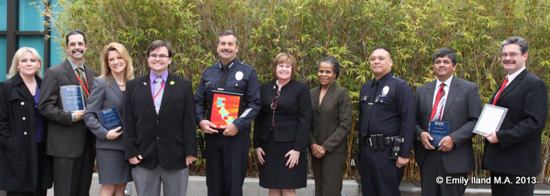 A large group of people from the Autism Society of Los Angeles and LAPD pose at an awards ceremony